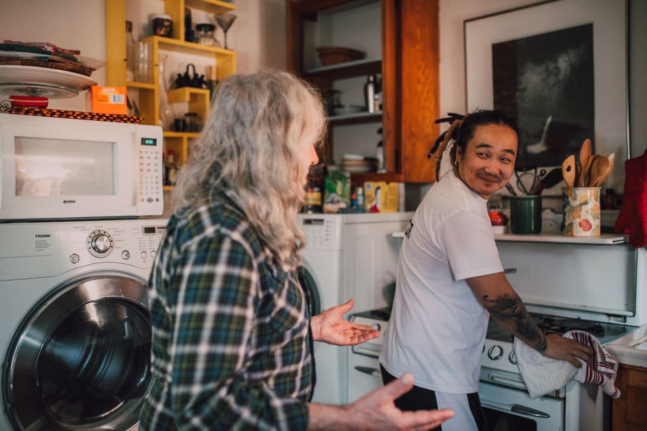 A home care aide helping an older adult at home.