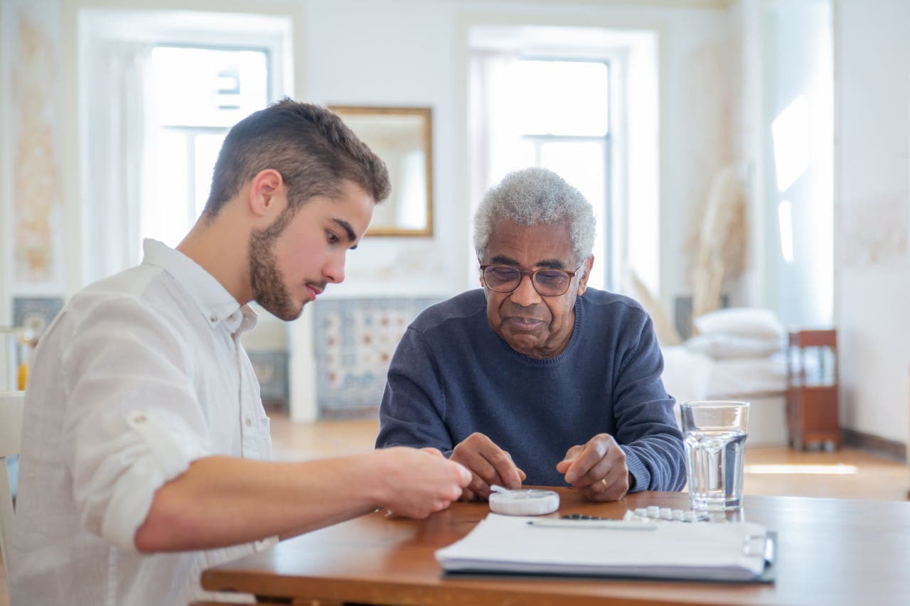 A caregiver helping an older adult recovering at home.