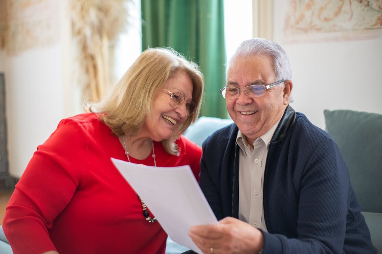 An older couple reviewing paperwork together at home.